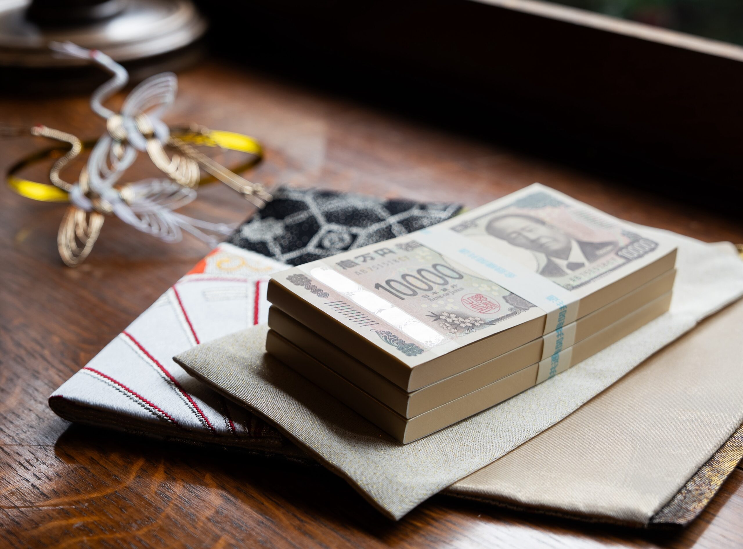 100万円の束をご祝儀袋に入れる様子